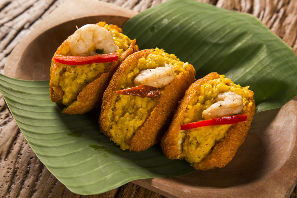 Acaraje - Traditional Brazilian fritters made with black-eyed peas filled with vatapa, caruru, tomato salad and sauteed shrimp. Typical food from Bahia.